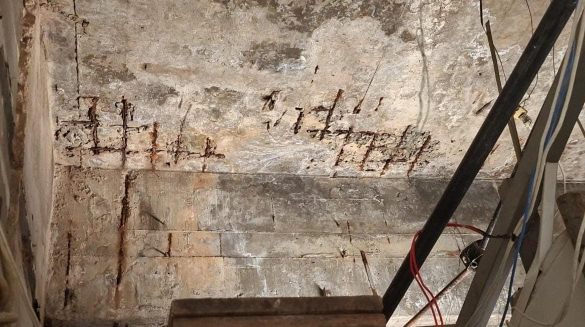 Laje e viga de garagem com armadura exposta e corroída, cobrimento de concreto perdido em toda a região