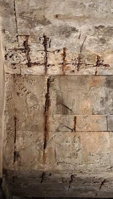 Viga de concreto com o traçado da armadura desenhado pela corrosão, barras e estribos expostos